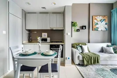 a kitchen and living room with a table and a couch at Stylish 1BR in the heart of Dubai - easy walk by the canal in Dubai