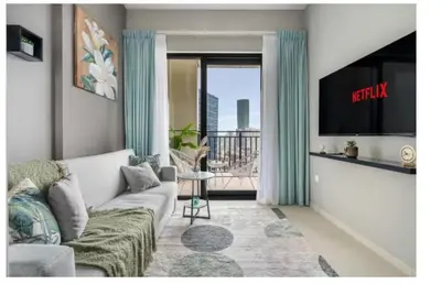 a living room with a couch and a tv at Stylish 1BR in the heart of Dubai - easy walk by the canal in Dubai