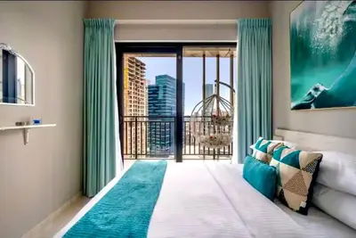 a bedroom with a bed and a large sliding glass door at Stylish 1BR in the heart of Dubai - easy walk by the canal in Dubai