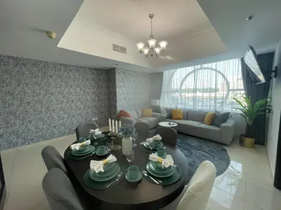 a living room with a table and a couch at Amazing 2 Bedroom in Al Rabia Tower in Majan 6PPL in Dubai