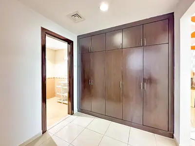 a large closet with wooden doors in a room at Amazing 2 Bedroom in Al Rabia Tower in Majan 6PPL in Dubai