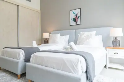 a bedroom with two beds and a blue headboard at Beachfront Bliss Luxurious 3-BR Stay in JBR in Dubai