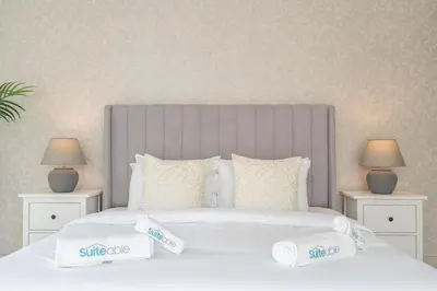 a white bed with two nightstands and two lamps at Beachfront Bliss Luxurious 3-BR Stay in JBR in Dubai