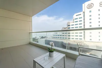 a balcony with a table and a view of a building at Beachfront Bliss Luxurious 3-BR Stay in JBR in Dubai