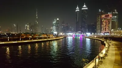 a city skyline at night with a river and buildings at CaiCai Homes AG Tower-Business Bay in Dubai