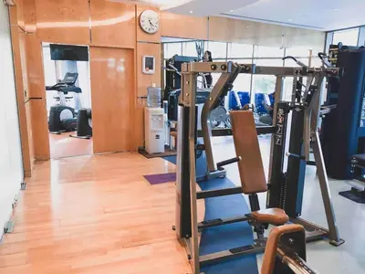 a gym with several tread machines and a clock at Luxury Sea View apartment in Dubai