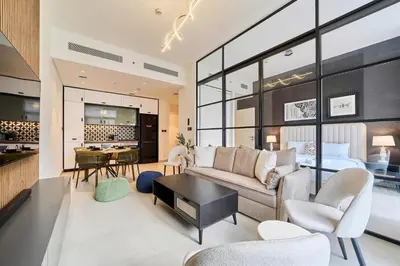 a living room with a couch and a bedroom at Elegant 2BR Living Steps from Dubai Hills Park in Dubai