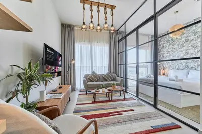 a living room with a couch and a table at Elegant & Bright 1BR Getaway Near Dubai Hills Park in Dubai