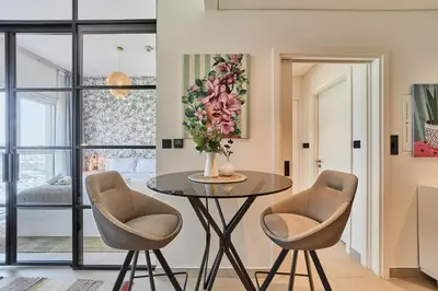 a dining room with a table and two chairs at Elegant & Bright 1BR Getaway Near Dubai Hills Park in Dubai