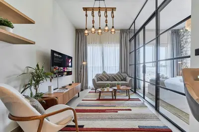 a living room with a couch and a table at Elegant & Bright 1BR Getaway Near Dubai Hills Park in Dubai