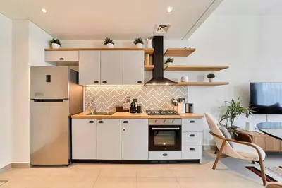 a kitchen with white cabinets and a stove at Elegant & Bright 1BR Getaway Near Dubai Hills Park in Dubai