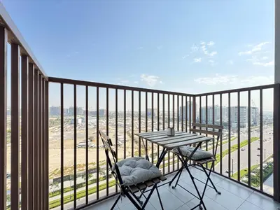 a balcony with a table and chairs and a view at Elegant & Bright 1BR Getaway Near Dubai Hills Park in Dubai
