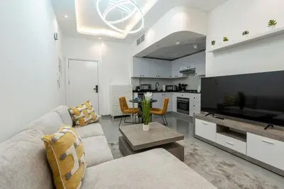 a living room with a couch and a tv and a kitchen at Dubai Marina - 1BHK Homely Apartment in Dubai