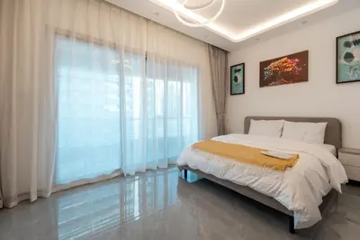 a bedroom with a large bed and a large window at Dubai Marina - 1BHK Homely Apartment in Dubai
