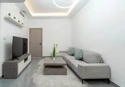 a living room with a couch and a tv at Dubai Marina - 1 BHK Elegant Apartment in Dubai