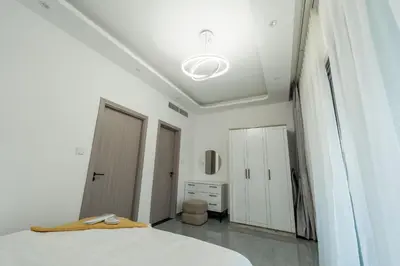 a white bedroom with a bed and a ceiling at Dubai Marina - 1 BHK Elegant Apartment in Dubai