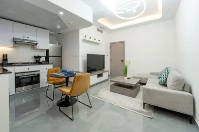 a kitchen and living room with a couch and a table at Dubai Marina - 1 BHK Elegant Apartment in Dubai