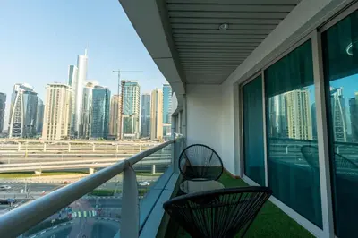 a balcony with two chairs and a view of a city at Dubai Marina - 1 BHK Elegant Apartment in Dubai