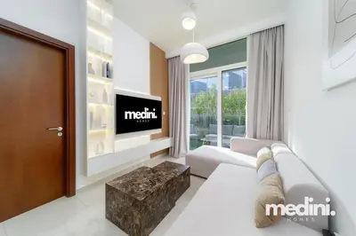 a living room with a couch and a tv at 10 min from Burj Khalifa - Sauna - Gym - Damac Reva in Dubai