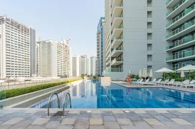 a swimming pool in a city with tall buildings at 10 min from Burj Khalifa - Sauna - Gym - Damac Reva in Dubai
