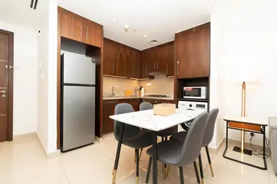 a kitchen with a table and chairs and a refrigerator at Full Burj Khalifa & Fountain Views Attached to Dubai Mall in Dubai
