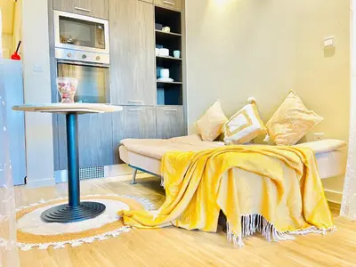 a bedroom with a bed with a yellow blanket on it at Spacious Spectacular Skyline View in Heart of Dubai in Dubai