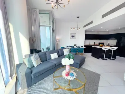 a living room with a couch and a table at 2 Bedroom Apartment with Spacious Private Garden in Dubai Marina in Dubai