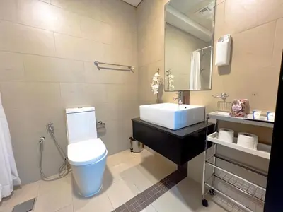 a bathroom with a white toilet and a sink at 2 Bedroom Apartment with Spacious Private Garden in Dubai Marina in Dubai