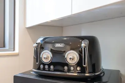 a black toaster sitting on top of a counter at StayShort - Bright and Airy 1-Bedroom Apartment Perfect for 4 in Dubai Marina in Dubai