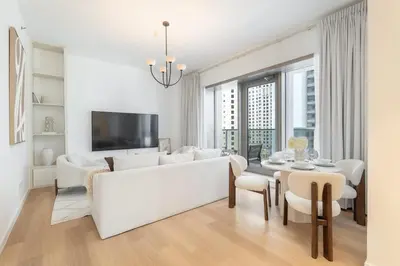 a white living room with a white couch and a table at StayShort - Bright and Airy 1-Bedroom Apartment Perfect for 4 in Dubai Marina in Dubai