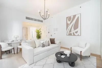 a living room with a white couch and a table at StayShort - Bright and Airy 1-Bedroom Apartment Perfect for 4 in Dubai Marina in Dubai