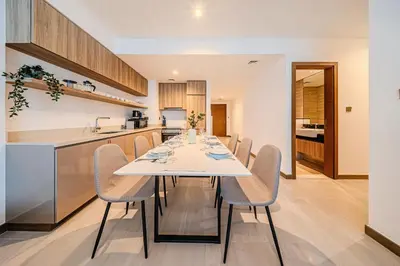 a kitchen and dining room with a white table and chairs at 2BR apartment in Missoni in Dubai
