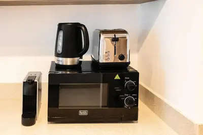 a coffeemaker with a coffee maker on top of it at 2BR apartment in Missoni in Dubai