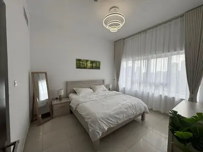 a bedroom with a bed and a mirror and a window at Silicon Heights II in Dubai