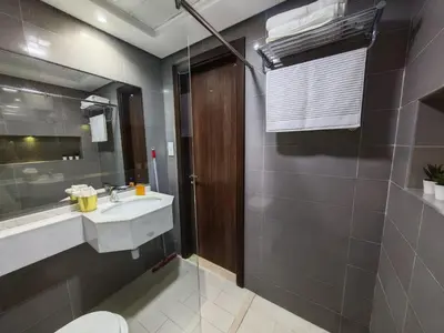 a bathroom with a sink and a toilet and a mirror at Silicon Heights II in Dubai