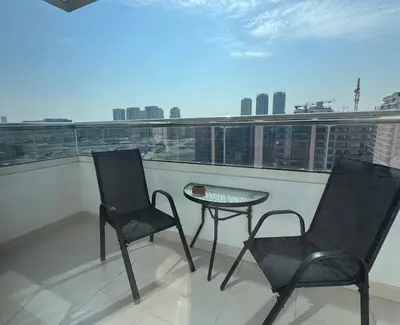 a balcony with two chairs and a table and a view at Silicon Heights II in Dubai