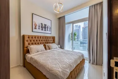 a bedroom with a bed and a large window at stylish 2 bedroom Apt in Business bay Dubai in Dubai