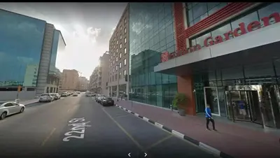 a person walking down a street in front of a building at Partition Room with window In Barsha Near Metro in Dubai