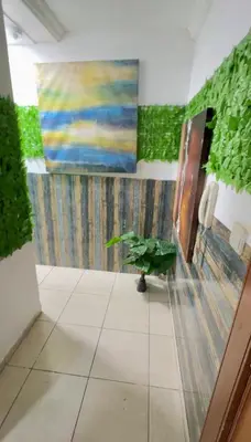 a bathroom with a painting on the wall and a plant at Cool valley homes in Dubai