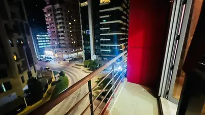 a view of a city at night from a balcony at Lavish Double Partition Room in Barsha Heights in Dubai