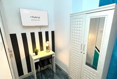 a small table with a lamp on it next to a door at Lavish Double Partition Room in Barsha Heights in Dubai