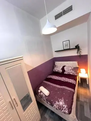a small bedroom with a bed and a mirror at Calm Partition Room Near Internet City Metro in Dubai