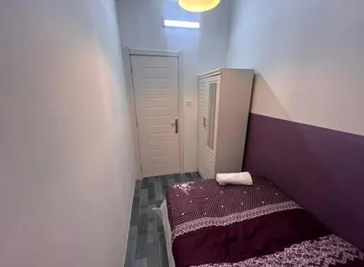 a small room with a bed and a door at Calm Partition Room Near Internet City Metro in Dubai
