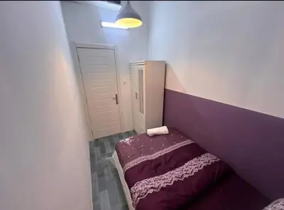 a small bedroom with a purple bed in the corner at Calm Partition Room Near Internet City Metro in Dubai