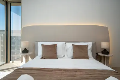 a bedroom with a large bed with a large window at Modern 1-Bedroom Retreat in MBR City in Dubai