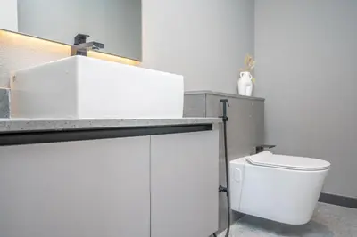 a white bathroom with a toilet and a counter at Modern 1-Bedroom Retreat in MBR City in Dubai
