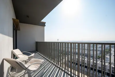 a balcony with chairs and a view of a city at Modern 1-Bedroom Retreat in MBR City in Dubai