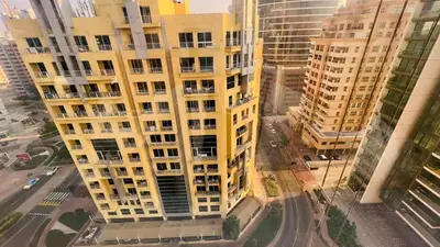 an overhead view of a tall yellow building at Twin Bed Partition Room Near ICM Metro in Dubai
