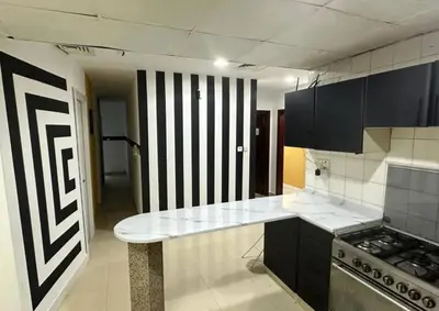 a kitchen with black cabinets and a counter top at City Stay Partition Room in al Barsha 1 Near Metro in Dubai