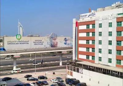 a parking lot with cars on a highway next to a building at City Stay Partition Room in al Barsha 1 Near Metro in Dubai
